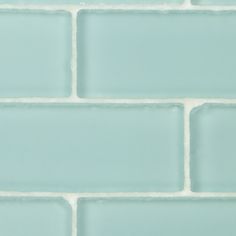 a close up view of a light blue brick wall with white grouting on it