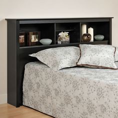 a bed with a black headboard and pillows