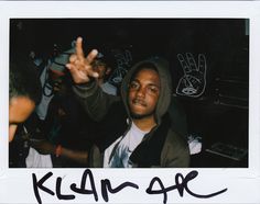 a polaroid photo of a man with his hand up in the air and two other people behind him