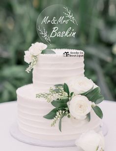 a wedding cake with white flowers and greenery