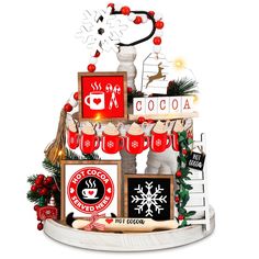 a christmas cake decorated with photos and other holiday decorations on it's tiered stand