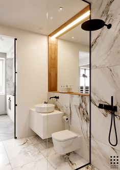 a white bathroom with marble walls and floor