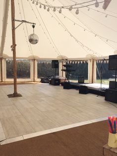 the inside of a marquee with lights and sound equipment on the dance floor