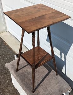 a small wooden table sitting in front of a garage door on top of a step