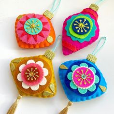 four colorful ornaments with tassels on top of each ornament are shown