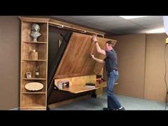 a man standing in front of a large wooden cabinet