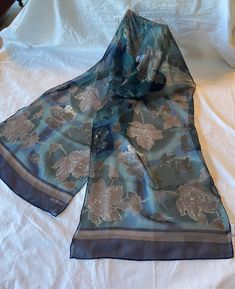 This is a lovely vintage scarf. It is by Designer Bill Blass. The signature is on the tag & in the printed design.  It's a long scarf that measures about 13" wide by 56" long. Made of silk. It is a floral print in teal, blue & brown.  In very good vintage condition. No soil or damage. Just lovely! Vintage Blue Silk Scarf For Spring, Blue Vintage Silk Scarf For Spring, Blue Vintage Silk Scarf, Vintage Blue Silk Scarf, Vintage Blue Floral Print Scarves, Bill Blass, Bleu Turquoise, Lovely Shop, Vintage Scarf