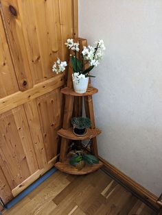 three tiered wooden shelf with flowers in it