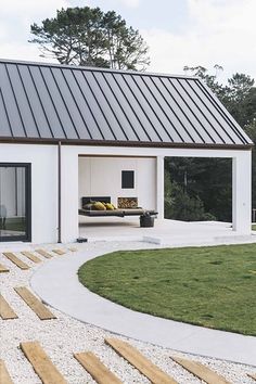 a white house with a black roof and stairs leading up to the front door area