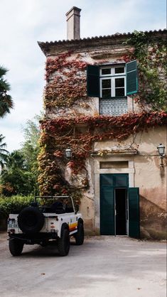 a jeep parked in front of a building with ivy growing on it's walls