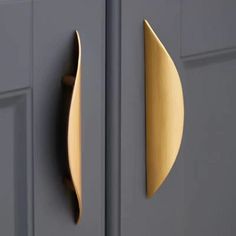 a close up of a door handle on the front of a gray door with gold accents