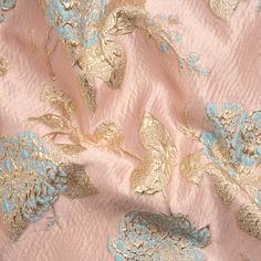 The stage is set: this Metallic Gold, Baby Blue and Pink Floral Luxury Brocade is ready for the spotlight. The sleek yet wrinkled pink face is the perfect base for a garden of blue and gold flowers to grow. They rise from the surface, thanks to the complex weave, to add a three-dimensional, grainy hand to the fabric. Exuding luxury, this heavyweight, lustrous brocade brings volume to any formal garment with its semi-structured drape. Own your night with stunning ballgowns, structured jackets, ci Luxury Sleek Semi-formal Dresses, Luxury Semi-formal Dress Shoes, Luxury Pink Brocade Traditional Wear, Luxury Pink Embroidered Fabric For Celebration, Luxury Brocade Sets With Motifs, Luxury Pink Brocade Sets, Luxury Embroidered Pink Fabric, Luxury Pink Brocade Dupatta, Luxury Pink Embroidered Fabric With Motifs