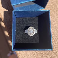 an engagement ring in a blue box on the ground with it's lid open