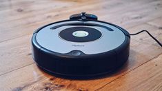 the robotic vacuum is on the wooden floor