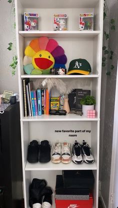 a white book shelf filled with books and shoes