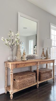 a wooden table with baskets underneath it and a mirror on the wall in front of it