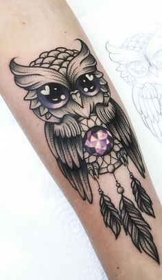 an owl tattoo on the arm with feathers