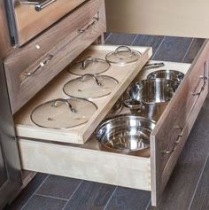 an open drawer with pots and pans in it