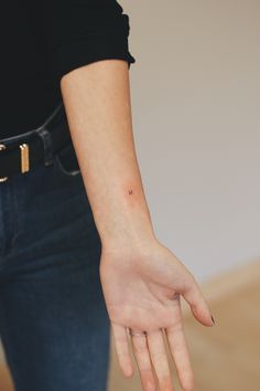 a woman's left hand with a tiny tattoo on her right wrist and finger