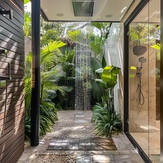 an outdoor shower in the middle of a tropical garden area with lots of greenery