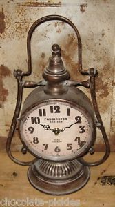 an old fashioned clock sitting on top of a wooden table next to a dirty wall