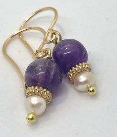 Find your everyday fancy with amethyst and pearl earrings Gold Amethyst Dainty Earrings, Dainty Gold Amethyst Earrings, Gold Amethyst Round Earrings, Gold Pearl Earrings With Natural Stones, Gold Amethyst Earrings With Ear Wire, Gold Natural Stones Drop Pearl Earrings, Gold Pearl Earrings With Round Beads For Gift, Handmade 14k Gold Filled Pearl Earrings For Anniversary, Purple Dangle Pearl Earrings As Gift