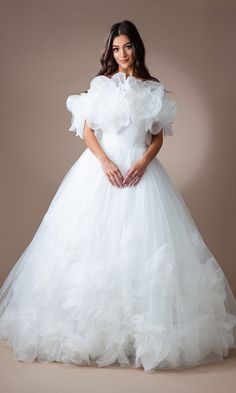 a woman in a white wedding dress with ruffled sleeves and an open neckline