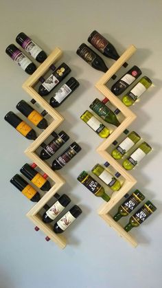 a wall mounted wine rack filled with lots of bottles on top of wooden shelves next to a white wall