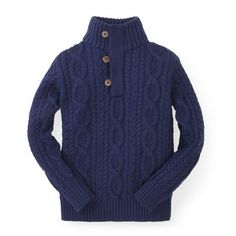 a blue cable knit sweater with buttons on the collar and cuffs, in front of a white background