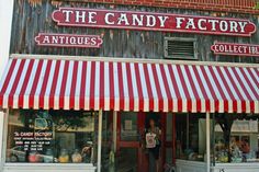 the candy factory antiques store has red and white striped awning