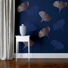 a vase sitting on top of a white table next to a blue wall