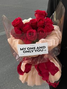 a bouquet of red roses wrapped in cellophane with a sign that says, my one and only you