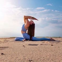 a woman is doing yoga on the beach