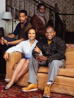 a group of people sitting on top of a couch in front of a stair case