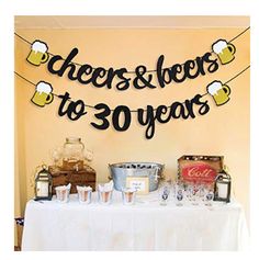 a table topped with lots of bottles and glasses next to a sign that says cheers to 30 years