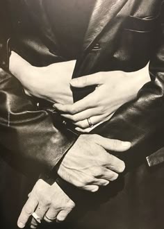 two people holding each other's hands in black and white