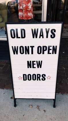 a sign that says old ways won't open new doors on the side walk