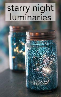 two jars filled with blue glitter sitting on top of a wooden table next to each other