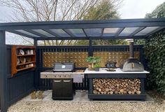 an outdoor bbq with grill, table and chairs