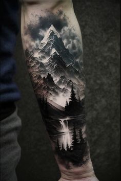 a man's arm with a mountain and forest tattoo on the left side of his arm