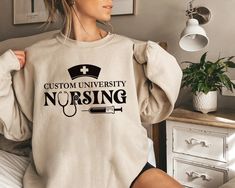 Standard Fit Custom Nursing School Sweatshirt, Personalized College Of Nursing Unisex Sweatshirt, Nursing Student Shirt, Customized Nurse Graduation Gift. 8.5 Oz./Yd² (Us) 14.1 Oz./L Yd, (CA), 80/20 Cotton/Polyester Blend Fleece Solid Colors & Gunmetal Heather: 80/20 Cotton/Polyester With 100% Cotton 20 Singles Face Yarn Grey Heather: 75/25 Cotton/Polyester All Other Heather Colors: 55/45 Cotton/Polyester (Charcoal Heather, Classic Navy Heather, Royal Heather, Army Heather) Split Stitch Double N Cheap Cotton Nursing Sweatshirt, Nursing School Crewneck, Nursing Sweatshirt Student, Nursing Student Shirts, Nursing Cotton T-shirt With Crew Neck, School Sweatshirts, Cotton Graphic Print T-shirt For Nursing, College Shirts, Nurse Graduation Gift