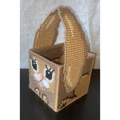 a small basket with an animal design on the front and sides, sitting on a table