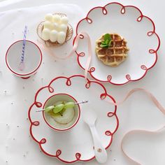 a table topped with plates and cups filled with food