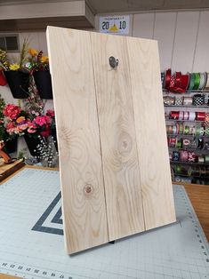 a piece of wood sitting on top of a table next to some scissors and spools of thread