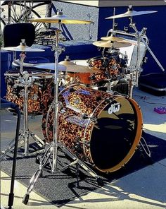 a close up of a drum set on the ground near a building with blue walls