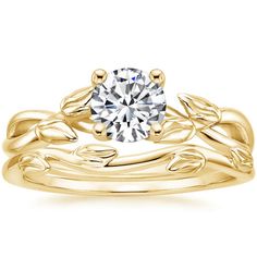 a yellow gold engagement ring with leaves on the band and a round diamond in the center