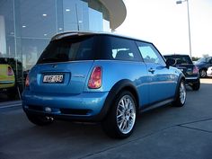 a small blue car parked in front of a building