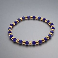 Blue Lapis Lazuli and Gold Beaded Stretch Bracelet Accented with 18K gold filled 4mm beads 4mm deep blue lapis beads A great addition to any bracelet stack. Handmade in Lincoln, Nebraska Blue Stretch Bracelet With Gold Beads, Blue Stretch Bracelet With Gold Round Beads, Gold Lapis Lazuli Beaded Bracelets With Round Beads, Gold Lapis Lazuli Bracelets For Gift, Hand-strung Gold Lapis Lazuli Bracelets, Gold Beaded Lapis Lazuli Bracelets, Gold Lapis Lazuli Spiritual Bracelets, Gold Stretch Bracelet With Gemstone Beads, Gold Rosary Bracelet With Gemstone Beads