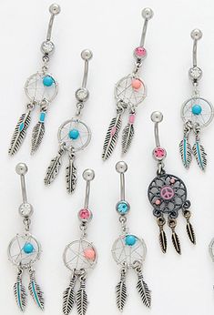 six pairs of dangling belly rings with dream catchers and feathers on them, all in different colors