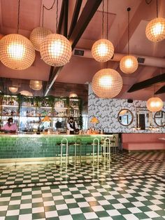 a checkered floor in a restaurant with lights hanging from the ceiling and chandeliers